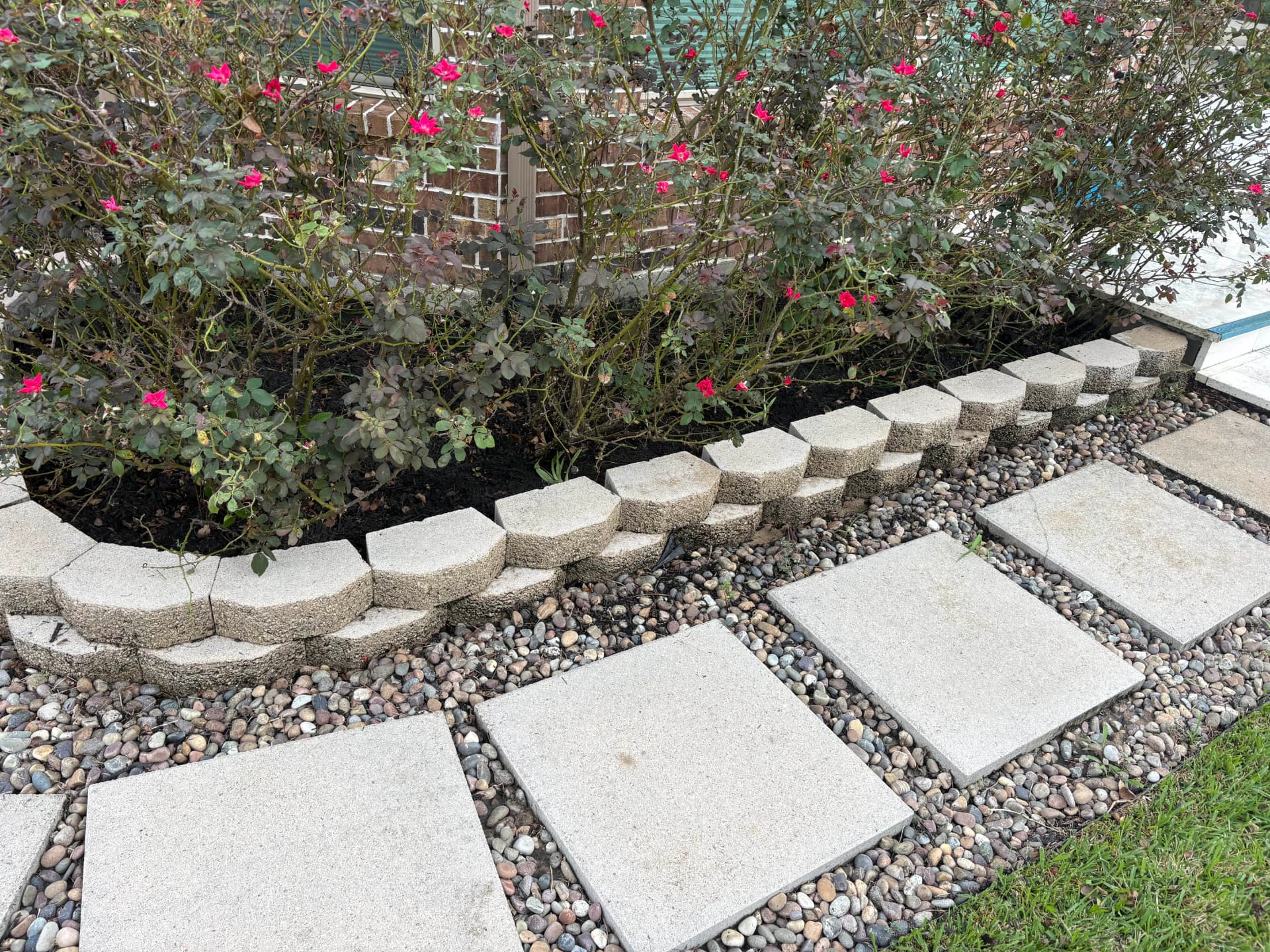 Stone stepping stones along a garden bed with a stone border — Integrative Services, Montgomery TX