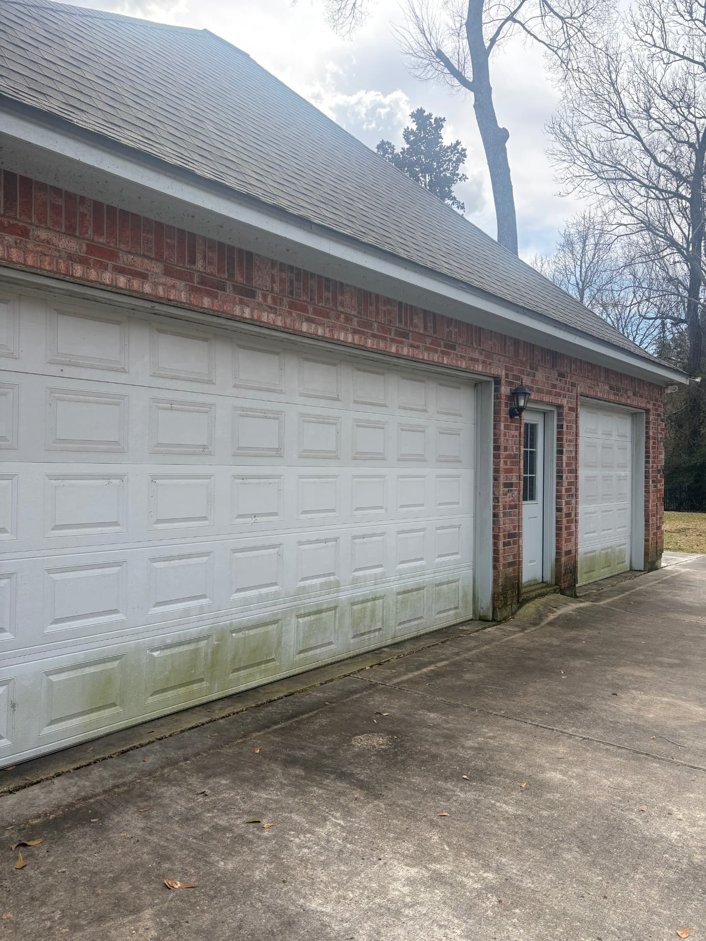 Garage doors with grime along the bottom before a wash — pressure washing in Montgomery, TX