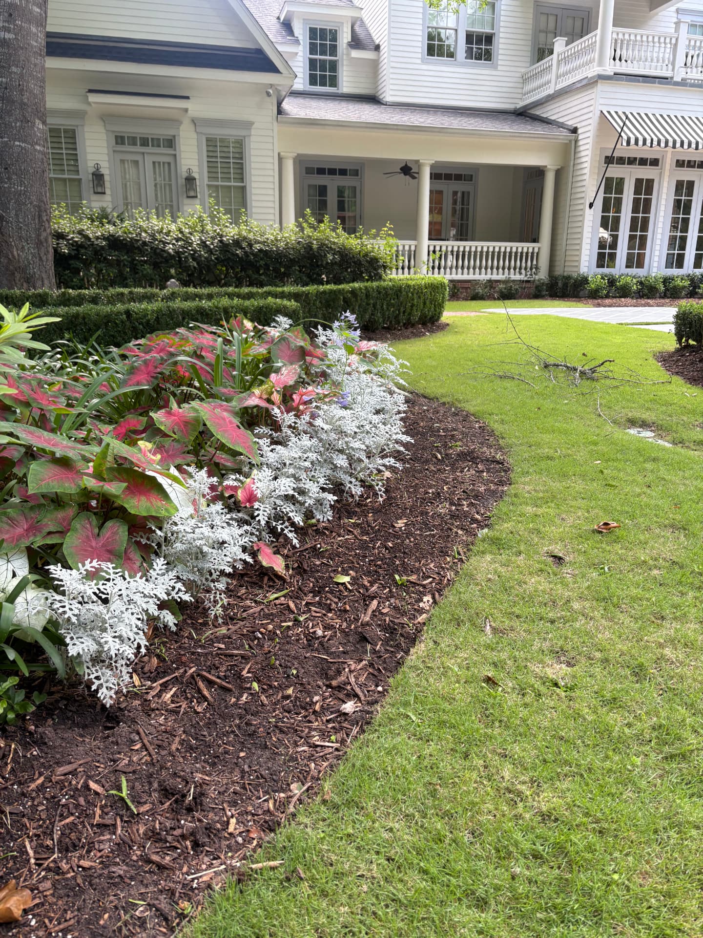 Colorful flower bed in front of a home with a porch — Integrative Services, Montgomery TX
